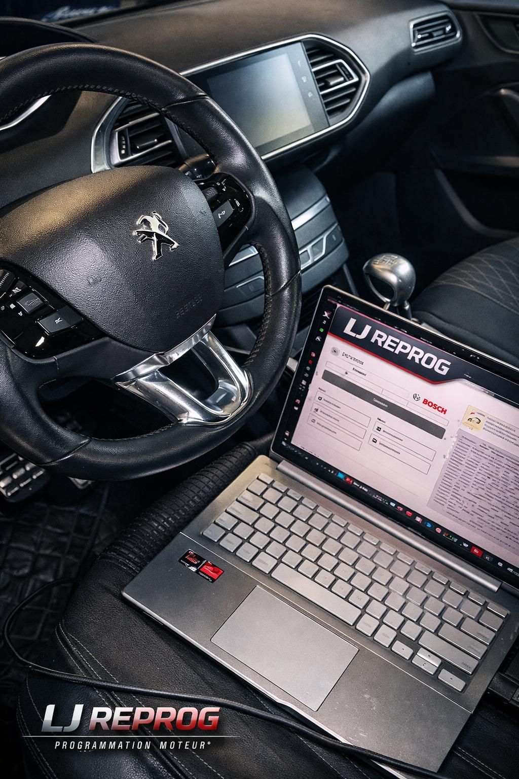 Ordinateur portable posé sur le siège passager, à côté du volant ; logiciel de diagnostic affiché. Réglages intérieurs.