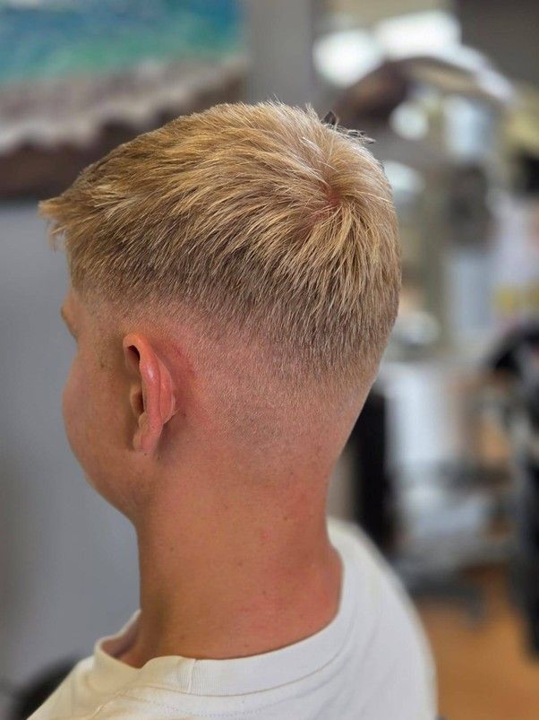 Ein junger Mann lässt sich in einem Friseursalon die Haare schneiden.