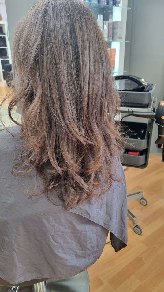 Eine Frau lässt sich in einem Salon die Haare schneiden.