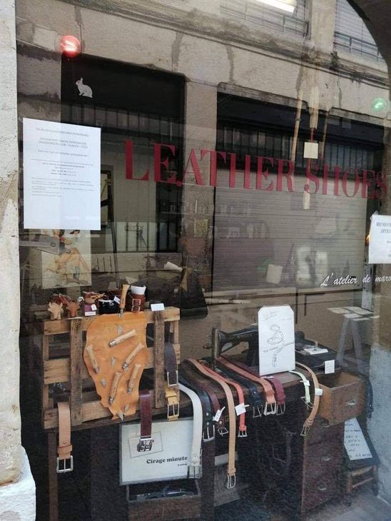 Vitrine d'un magasin de maroquinerie avec des ceintures et des sacs exposés à l'intérieur
