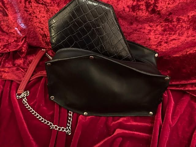 Pochette matelassée noire et sac noir clouté sur tissu velours rouge avec bandoulière chaîne argentée