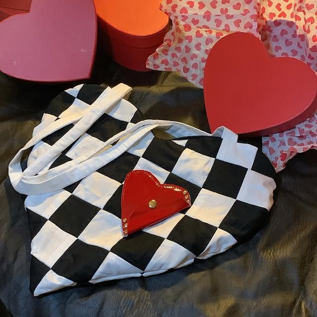 Sac cabas à carreaux noirs et blancs avec anses blanches, orné d'un cœur rouge entouré de cœurs roses et rouges.
