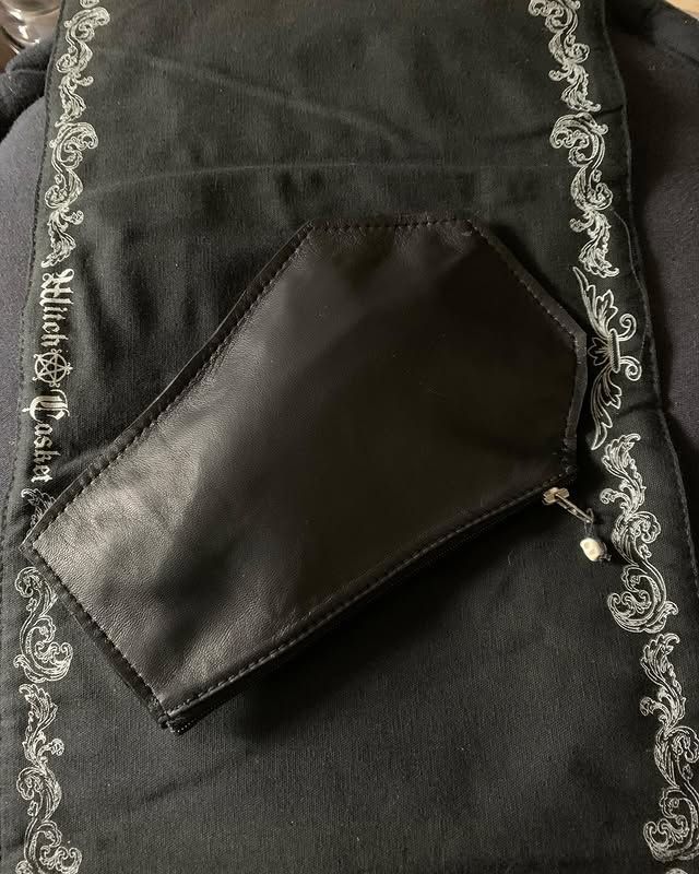 Pochette noire avec bordure de perles argentées sur fond de tissu foncé