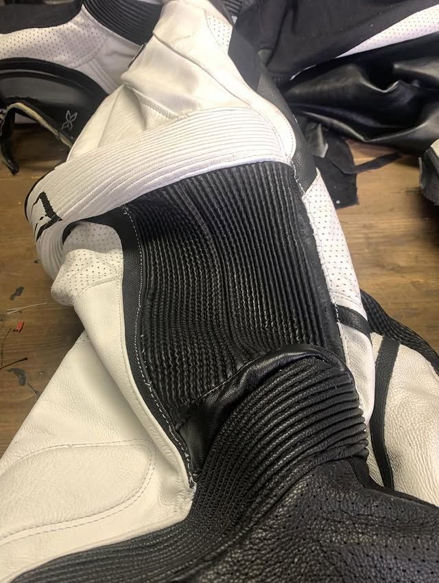 Gros plan sur une botte noire et blanche en tissu côtelé et à lacets, posée sur un sol en bois.