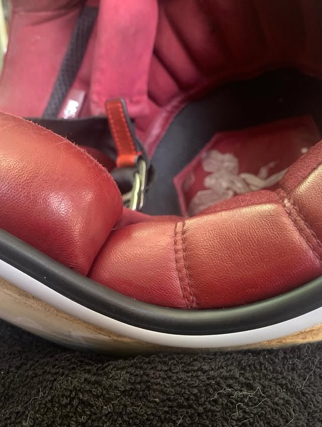 Gros plan sur un casque en cuir rouge sur une surface texturée