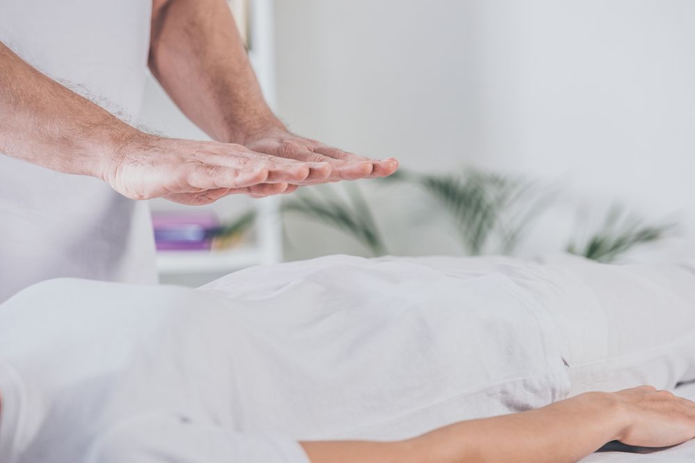 Una mujer está acostada en una cama recibiendo un masaje de un hombre.