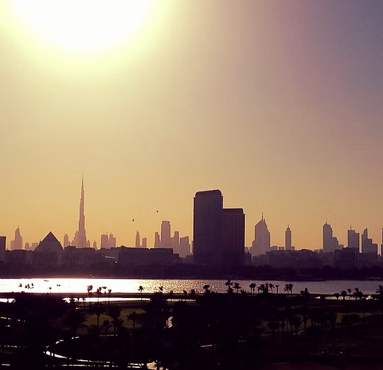 Die Skyline einer Stadt zeichnet sich vor dem Sonnenuntergangshimmel ab