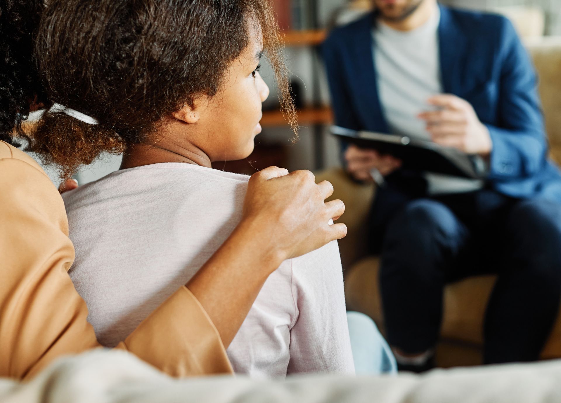 Un enfant avec la main de sa mère sur son épaule