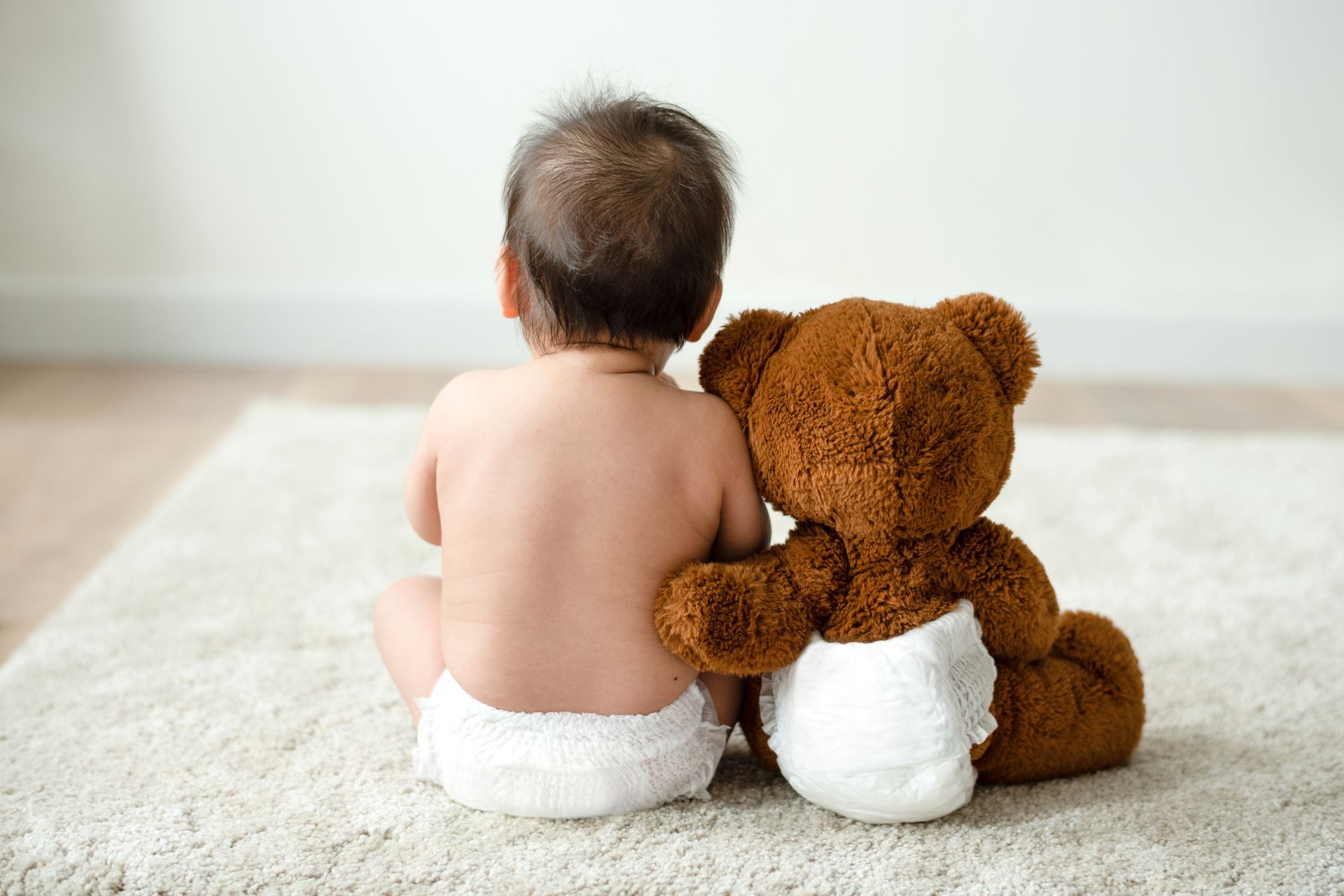 Un bébé avec sa peluche