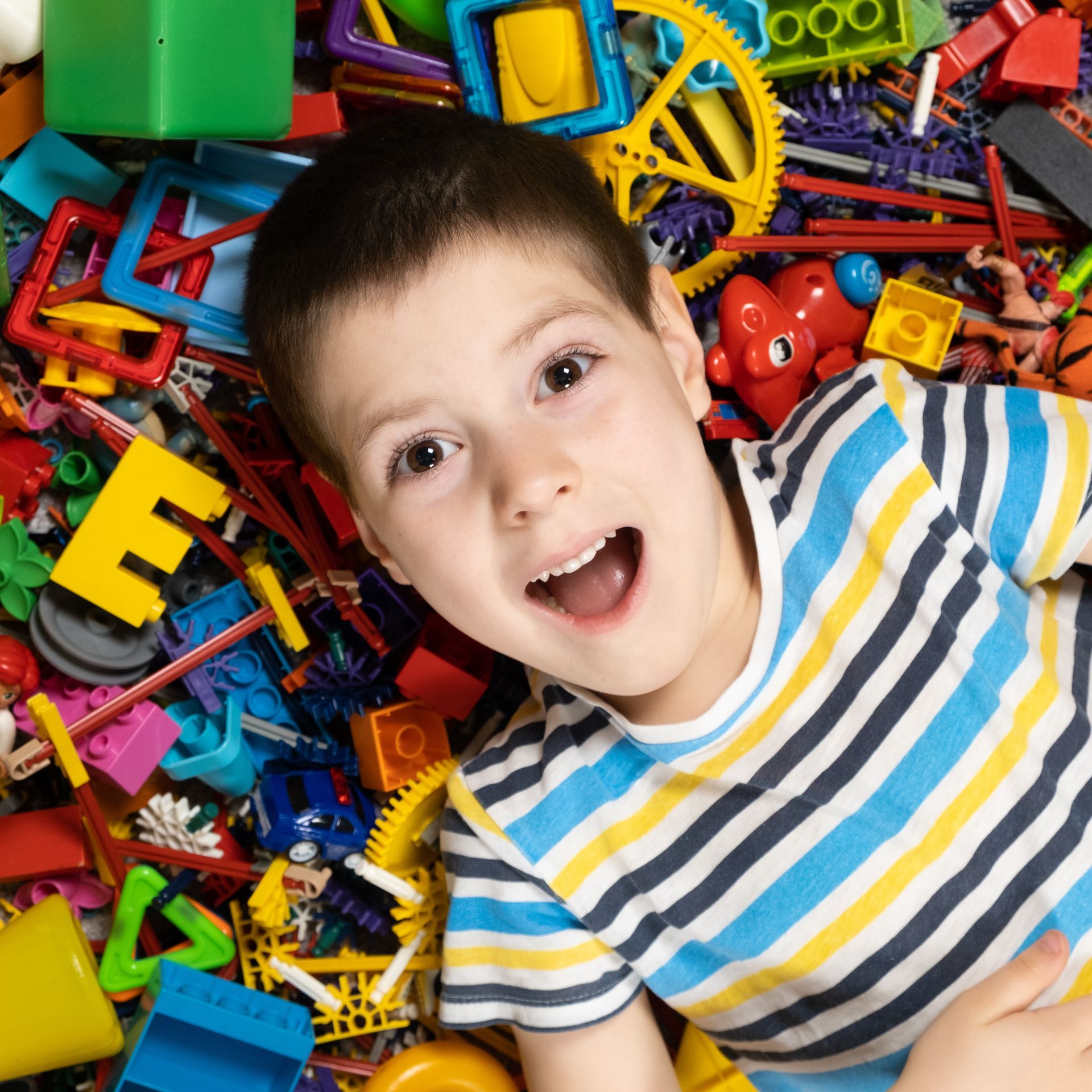Un enfant couché sur des jeux de construction