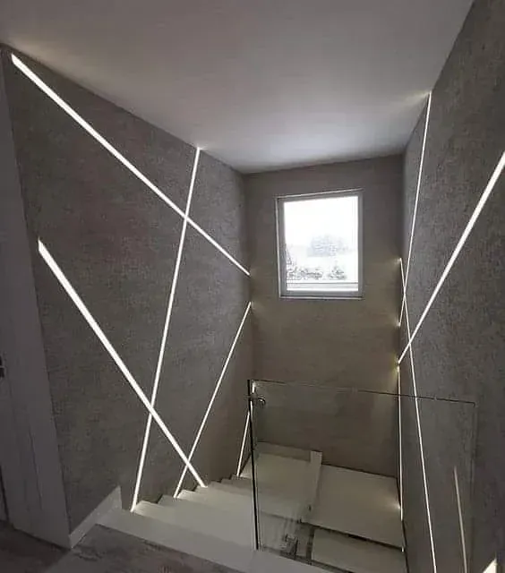 Una escalera con barandilla de cristal y una ventana.