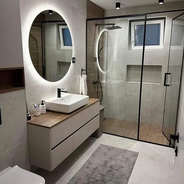 Un baño con lavabo, inodoro, ducha y espejo.