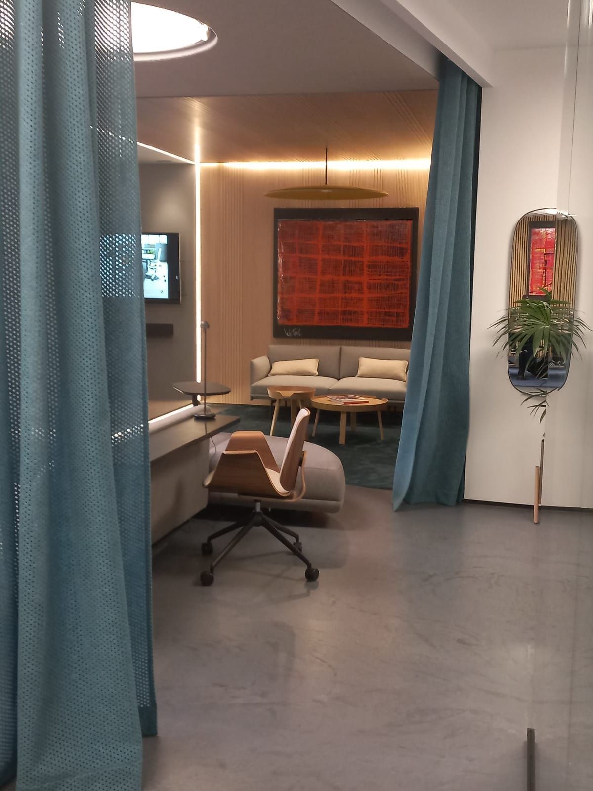 Una sala de estar con un sofá y una silla detrás de una cortina azul.