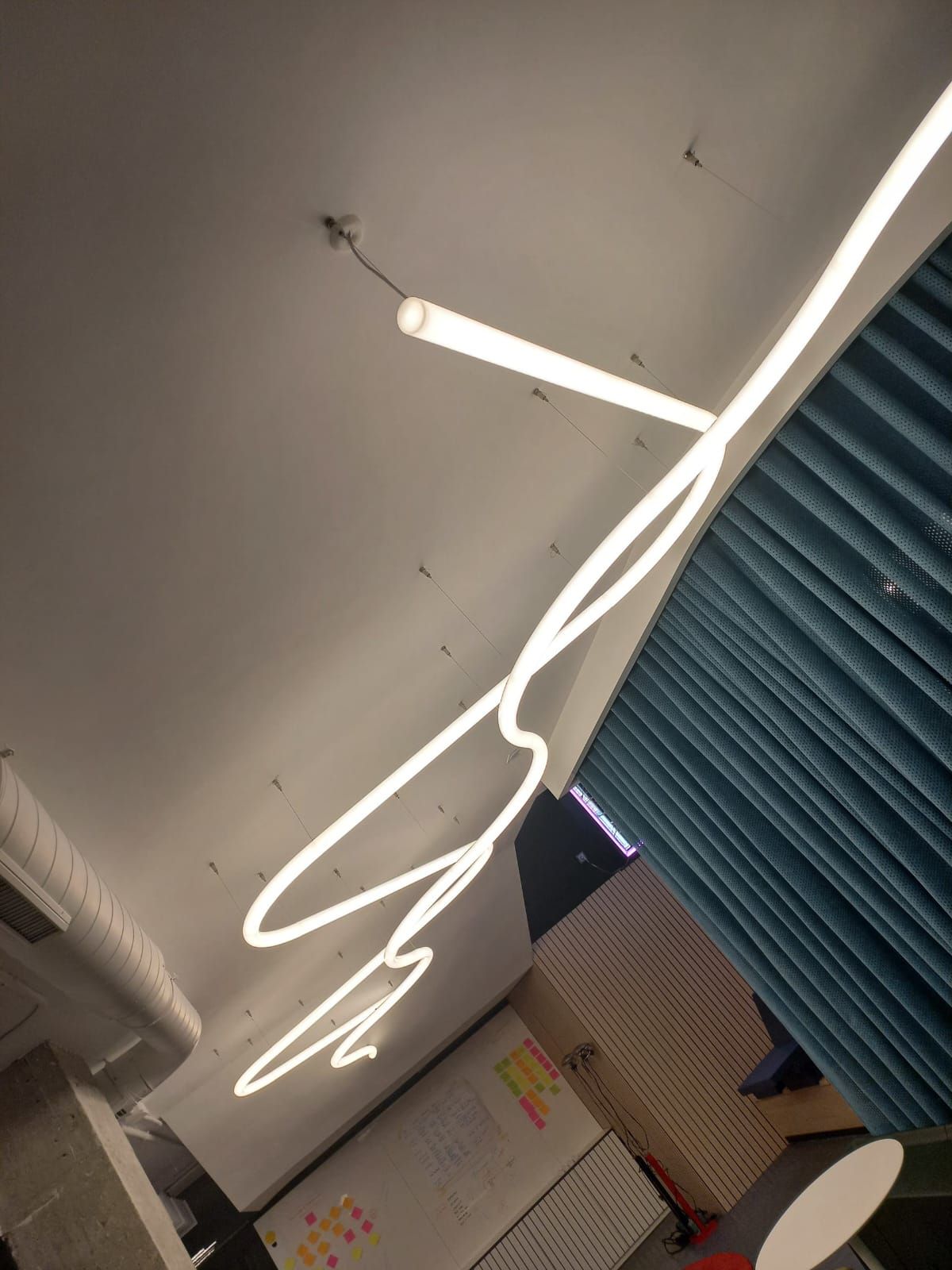 Una habitación con una cortina azul y un letrero de neón que dice amor.