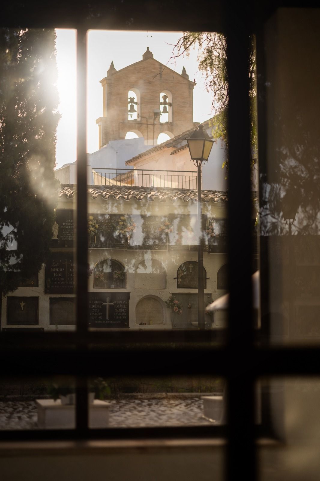 Una vista de una iglesia a través de una ventana con el sol brillando a través de ella.