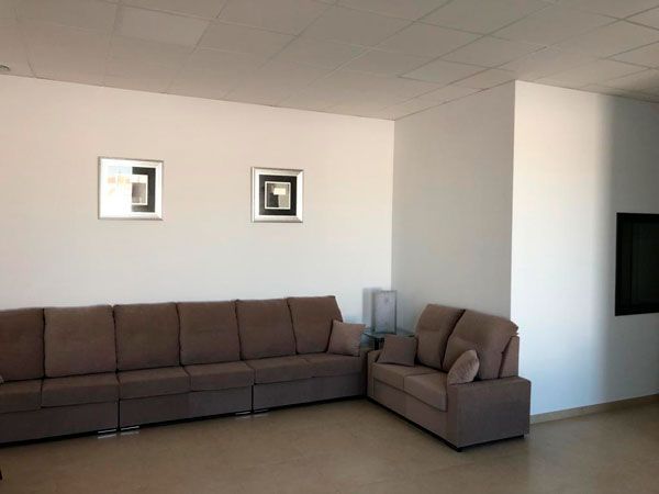 Una sala de estar con un sofá grande y dos sillas.