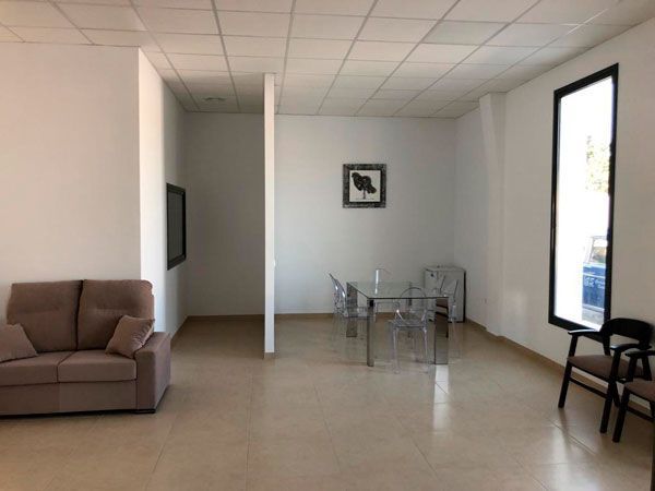 Una sala de estar con un sofá, una mesa y sillas.