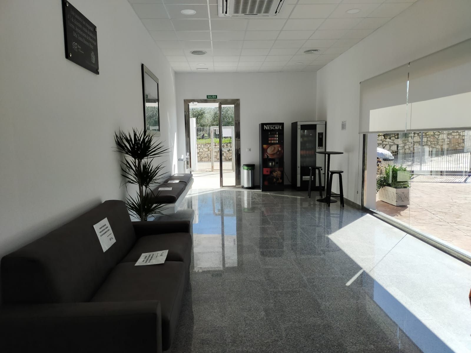 Una sala de espera con un sofá y una mesa