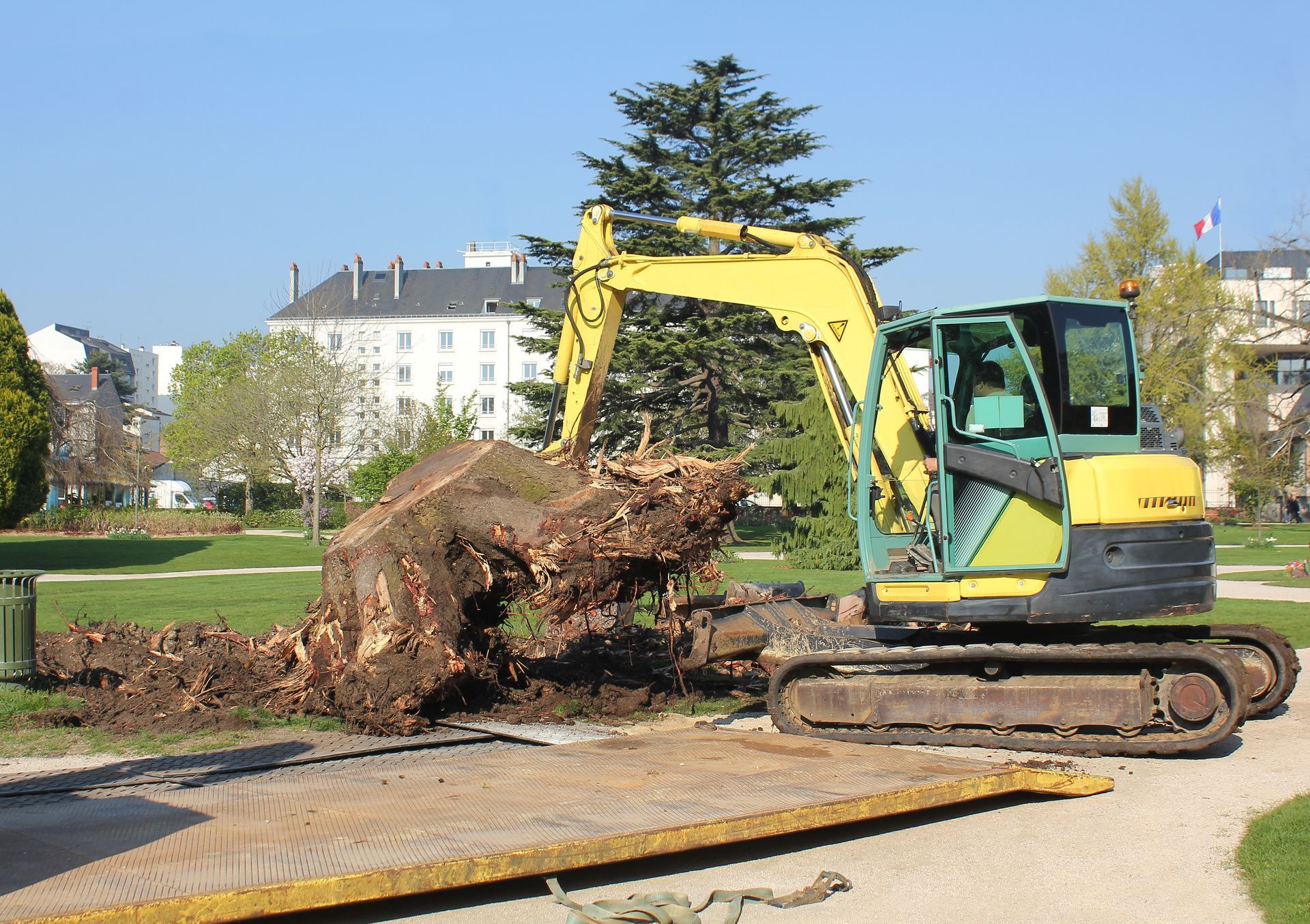 Une pelle qui enlève une grosse souche d'arbre
