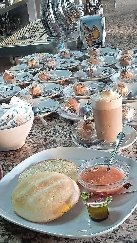 Un plato de comida con un sándwich y una taza de café en una mesa.