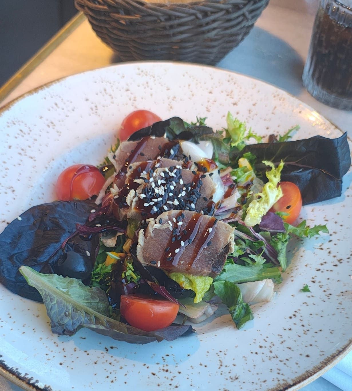 Un plato blanco cubierto con una ensalada de carne y verduras.