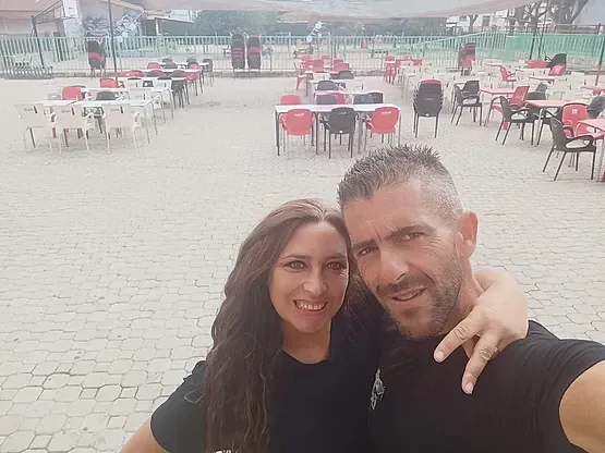 Un hombre y una mujer posan para una foto frente a un restaurante.