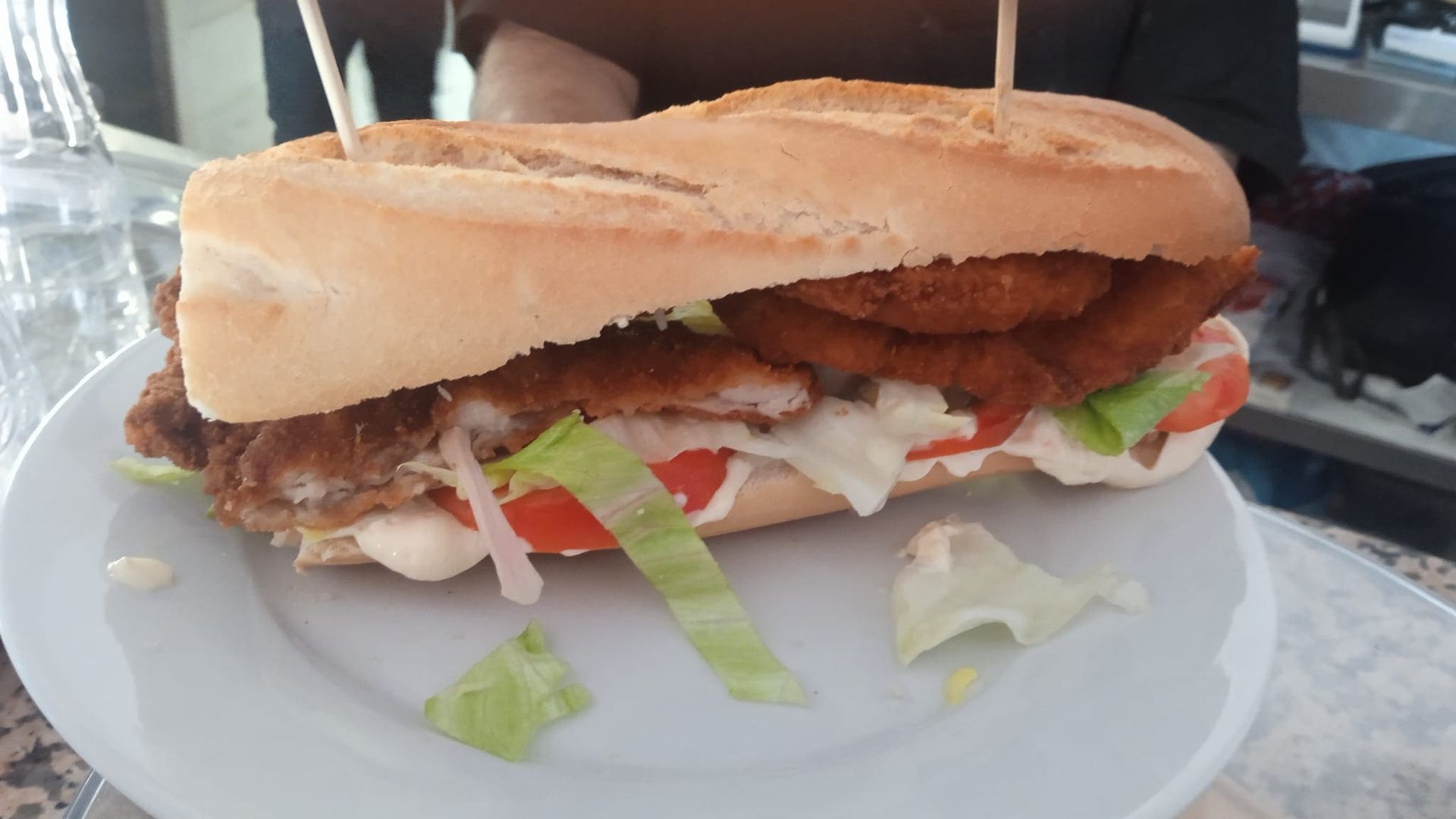 Un primer plano de un sándwich en un plato sobre una mesa.