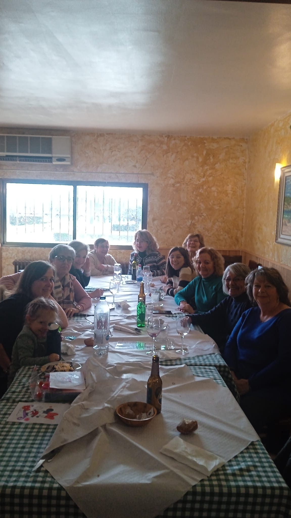 Un grupo de personas está sentado en una mesa larga en un restaurante.