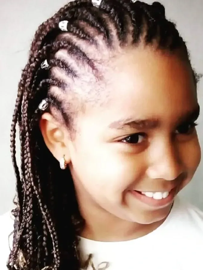 Chica con cabello trenzado y una sonrisa brillante.