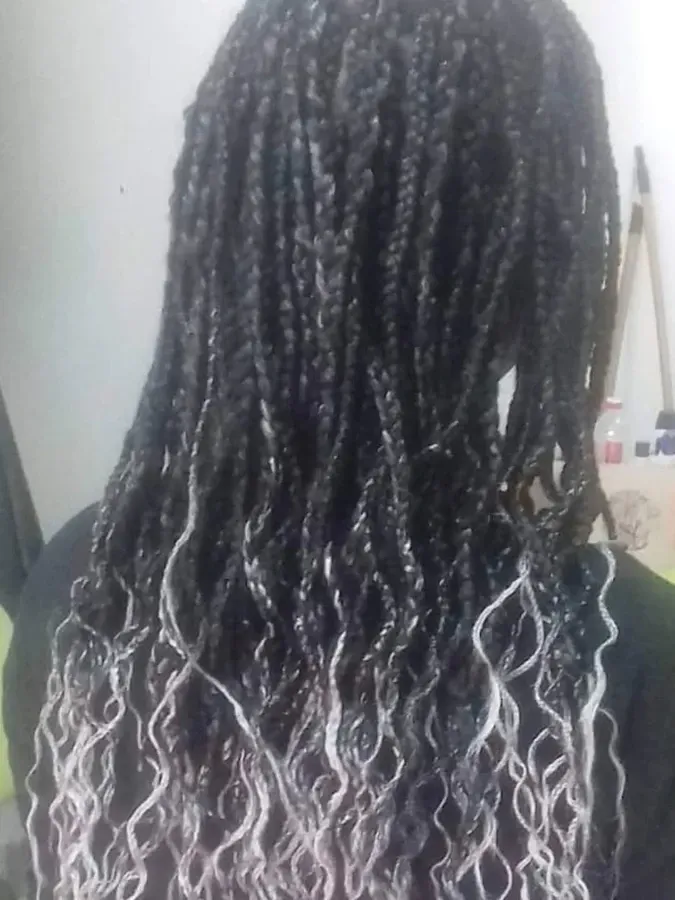 Cabello negro trenzado con puntas blancas y rizadas.