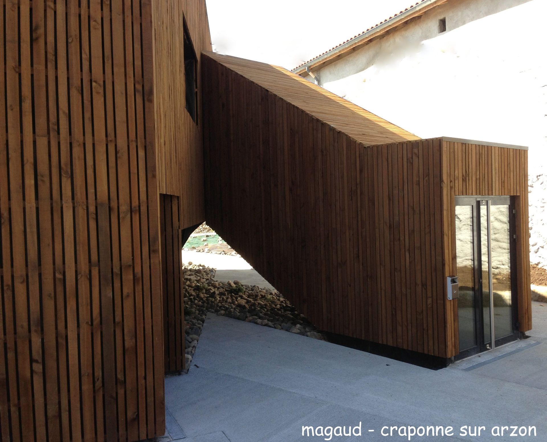 Extérieur du bâtiment en bois avec rampe et porte d'entrée.