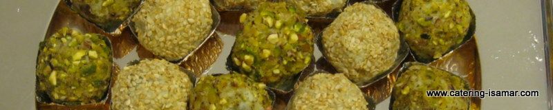 Surtido de pasteles o galletas redondas cubiertas con pistachos triturados en una bandeja.