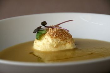 Postre en un tazón blanco, decorado y servido en un caldo ligero.