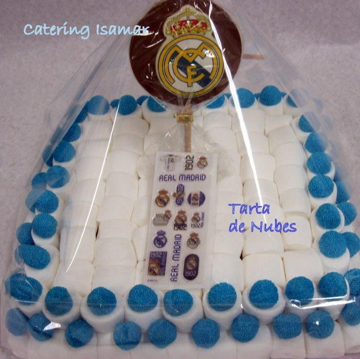 Tarta rectangular blanca con ribete azul y adorno del emblema del Real Madrid.