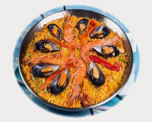 Paella de marisco en una sartén azul con mejillones, gambas y pimientos rojos.