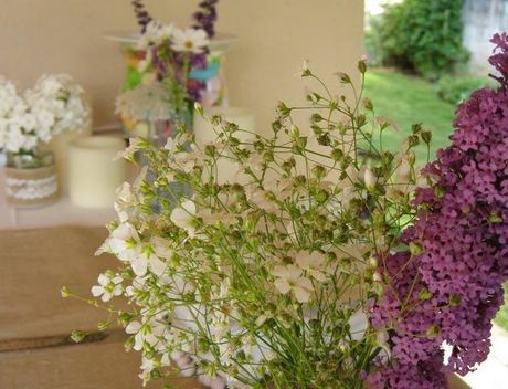 Ramo de flores blancas y moradas en un ambiente interior con iluminación tenue.