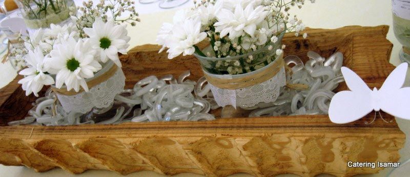 Bandeja rústica de madera con flores blancas, cinta de encaje y una decoración de mariposa rosa.