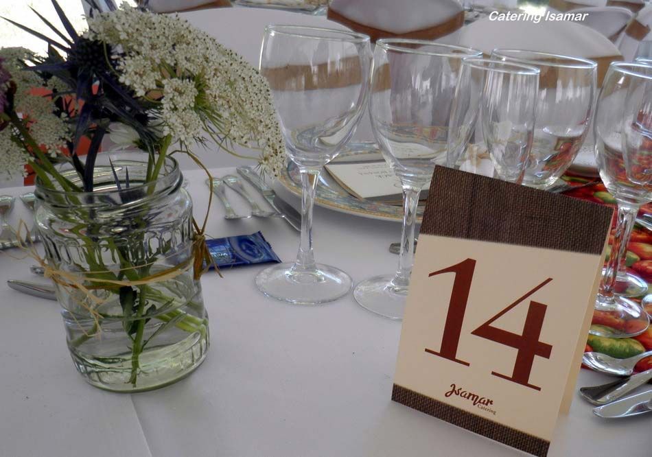 Decoración de mesa con flores y una tarjeta de madera con el número de mesa