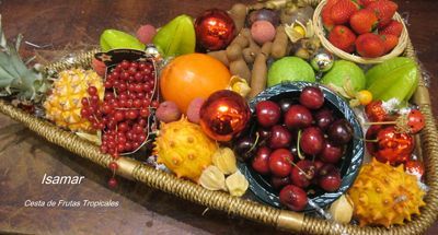 Cesta colorida con frutas variadas, que incluyen uvas, naranjas, manzanas, plátanos y fresas.