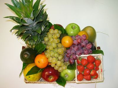 Variedad de frutas frescas, como uvas, manzanas, naranjas, fresas y kiwis, dispuestas en una colorida exhibición.