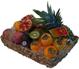 Surtido de frutas tropicales en una cesta de mimbre, que incluye piña, kiwi, naranjas y maracuyá.