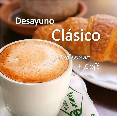 Desayuno clásico: café en taza blanca y croissant sobre mesa de madera.