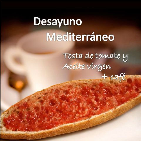Desayuno mediterráneo: tostada de tomate y aceite virgen con café sobre fondo desenfocado.