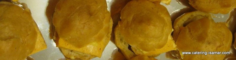 Tres pasteles con forma de flor de color amarillo dorado en una bandeja, con una pequeña marca de agua en la parte inferior derecha.