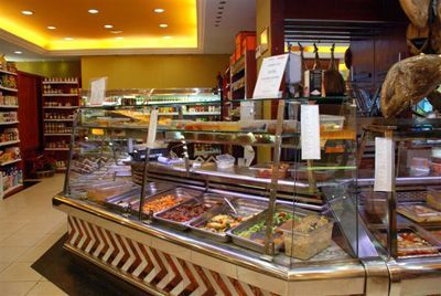 Mostrador de panadería con una variedad de pasteles y dulces en una tienda bien iluminada.