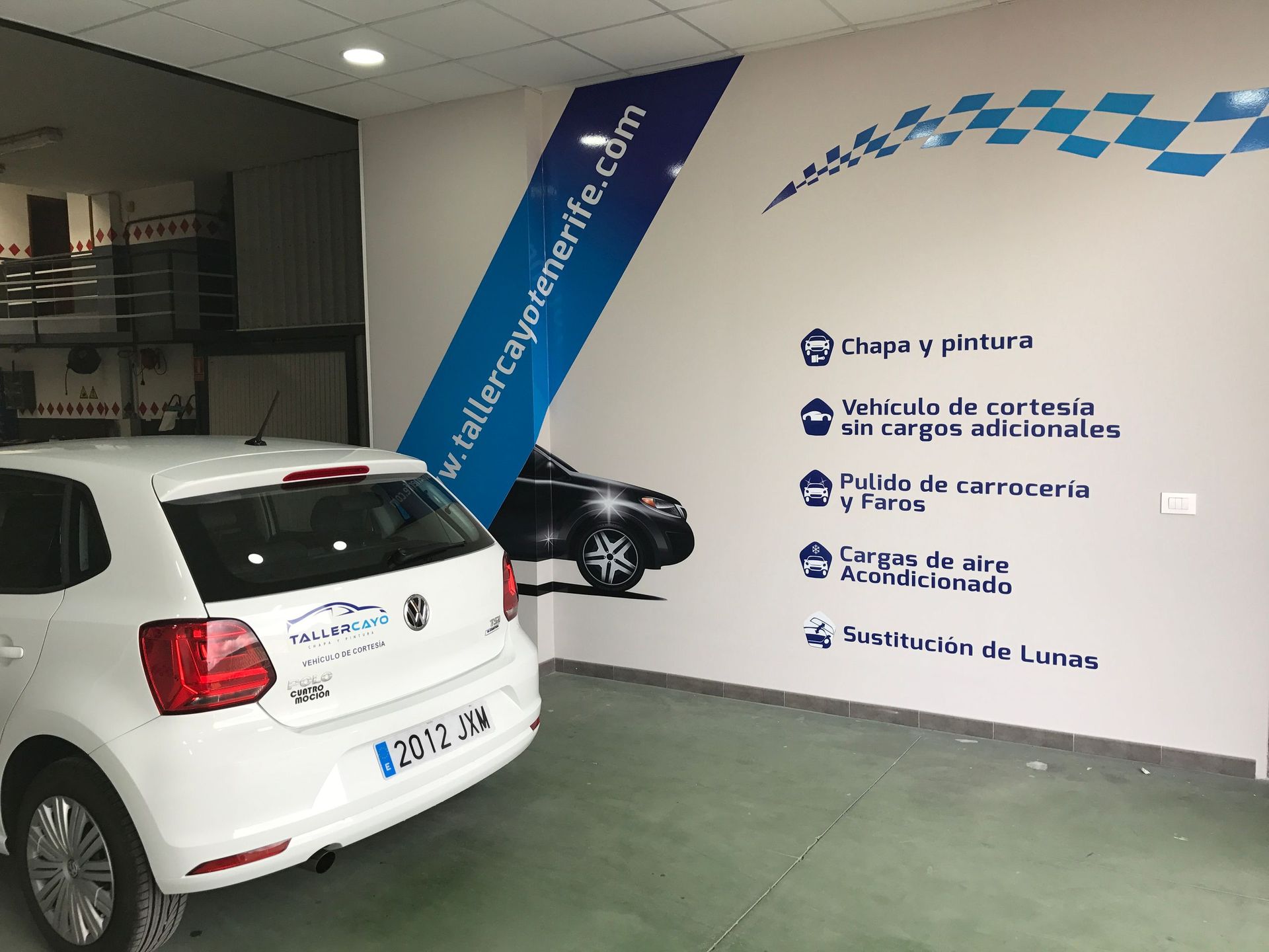 Un Volkswagen Polo blanco está aparcado en un garaje.