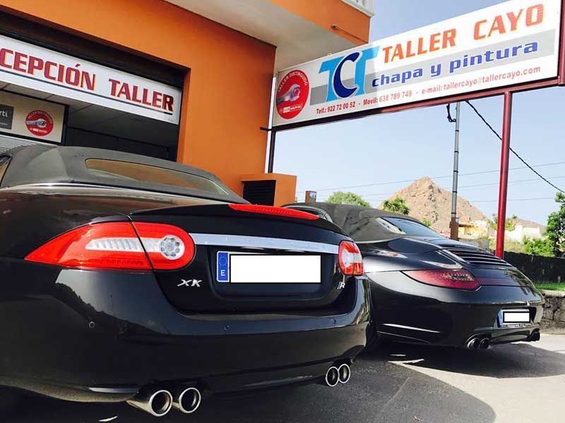 Dos coches están aparcados frente a un cayo alto.