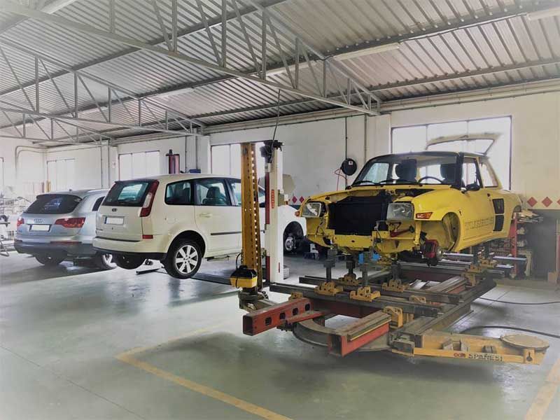 Un coche amarillo está estacionado en un elevador en un garaje.