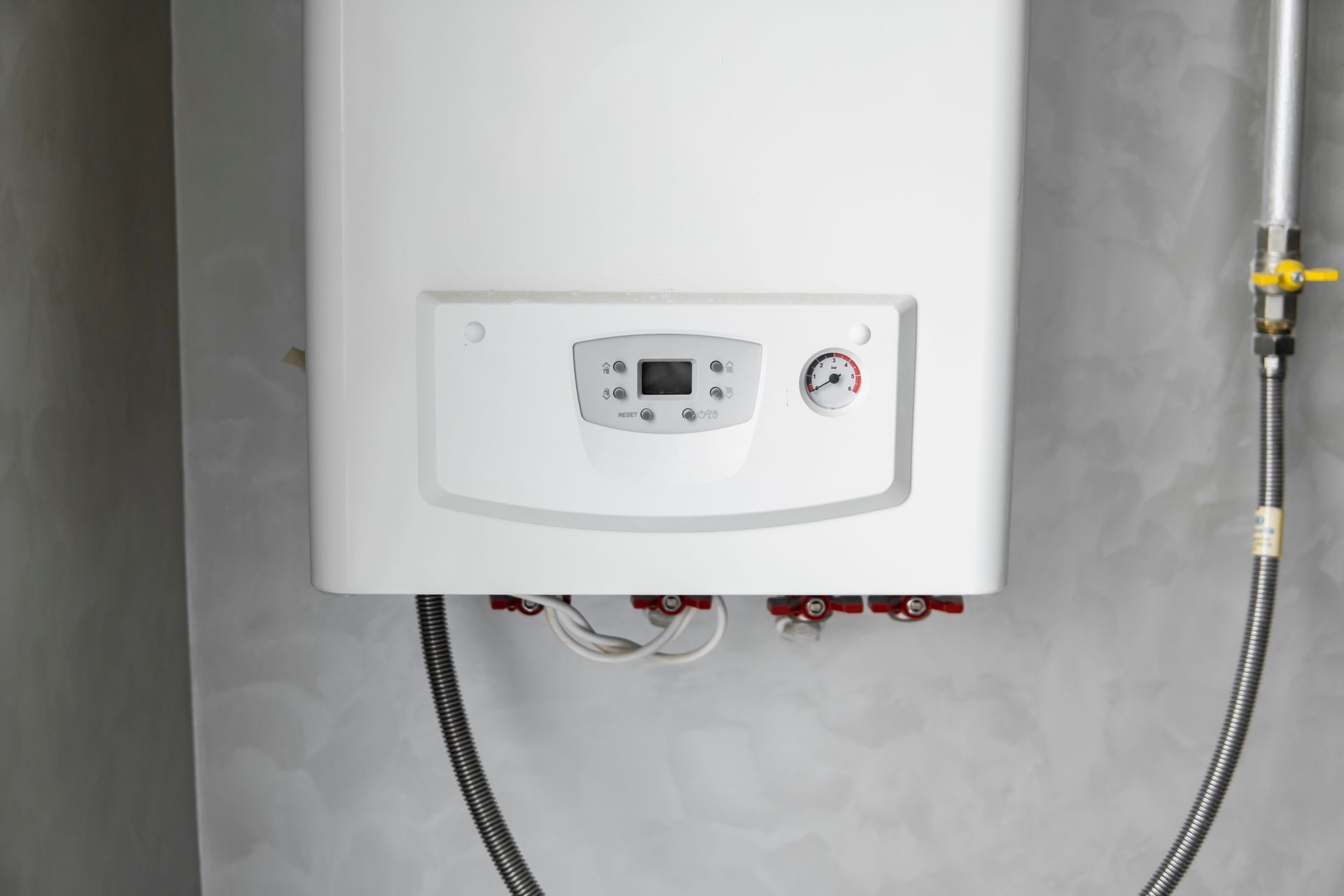 Chauffe-eau mural blanc avec panneau de commande numérique et tuyaux raccordés.