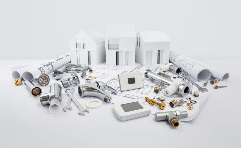 Outils de plomberie, pièces métalliques, représentations de maison en carton blanc et plan.